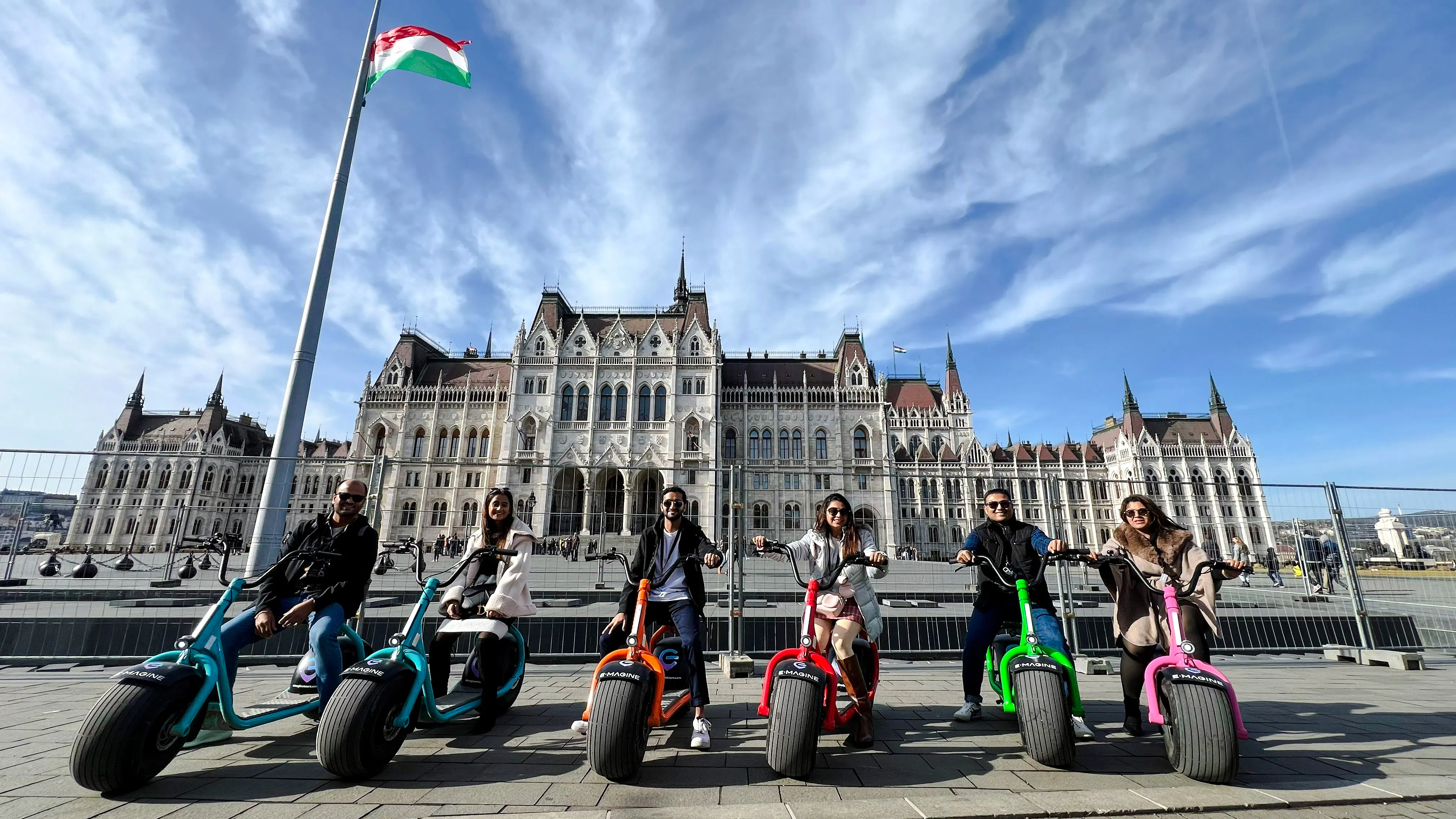 E-scooter riders in front of the Hungarian Parliament Building, Budapest.