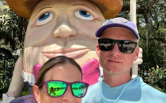 Humpty Dumpty statue with visitors in New Orleans park, part of city exploration game.