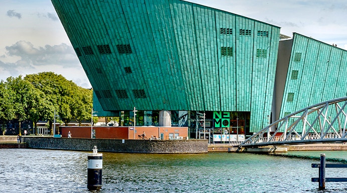NEMO Science Museum in Amsterdam with its distinctive green architecture by the water.