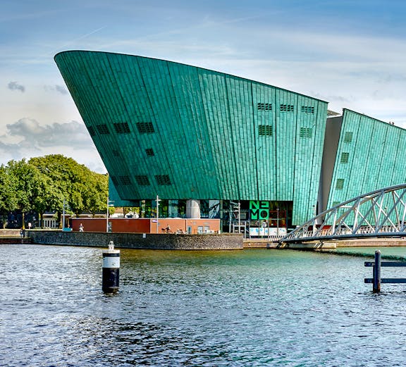 NEMO Science Museum in Amsterdam with its distinctive green architecture by the water.