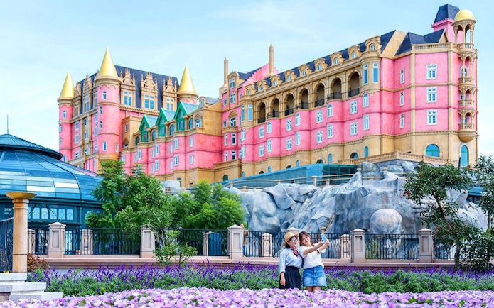 Tourist taking a photo in front of Luna Castle, Ba Na Hills, Vietnam.