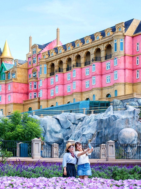 Tourist taking a photo in front of Luna Castle, Ba Na Hills, Vietnam.