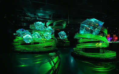 Illuminated art installation with green spirals at Art Aquarium Ginza.