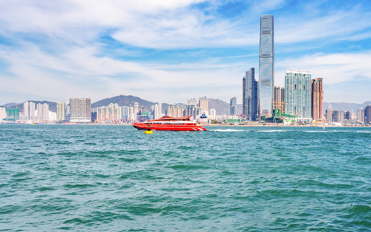 TurboJET ferry traveling from Hong Kong to Macau with city skyline in the background.