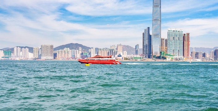 TurboJET ferry traveling from Hong Kong to Macau with city skyline in the background.