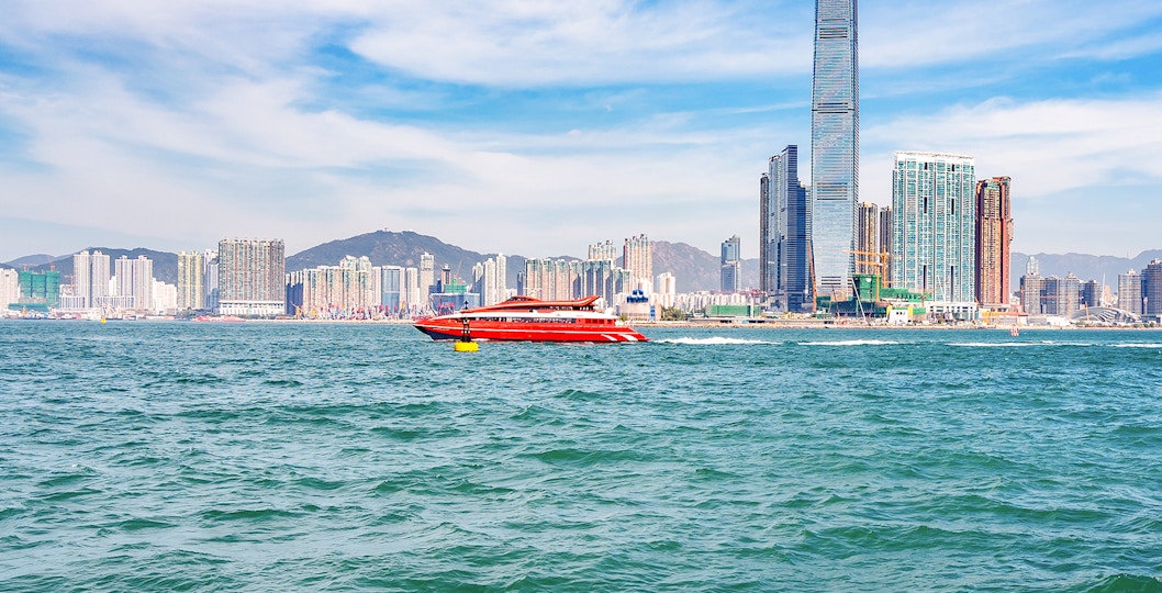 TurboJET ferry traveling from Hong Kong to Macau with city skyline in the background.