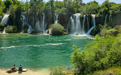 Tourists enjoying a picnic by Kravica Waterfalls in Bosnia and Herzegovina.
