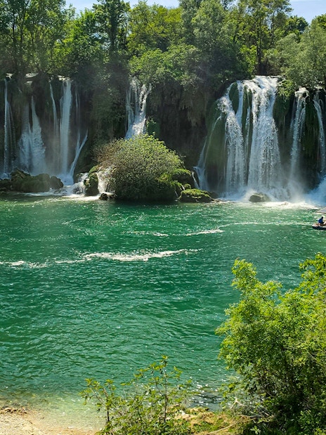 Tourists enjoying a picnic by Kravica Waterfalls in Bosnia and Herzegovina.