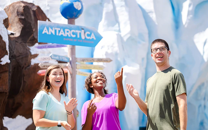 Visitors enjoying Antarctica realm at SeaWorld Orlando with icy backdrop.