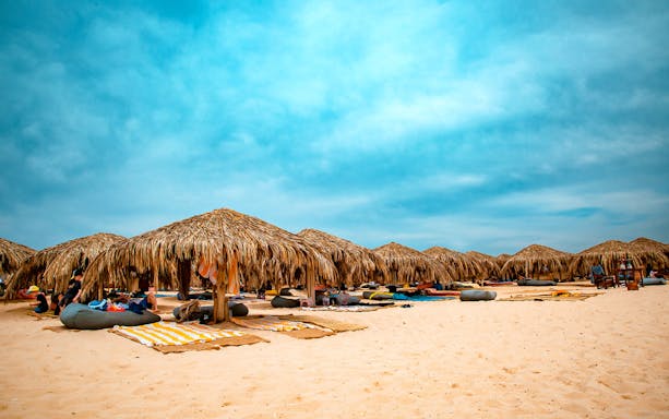 Straw beach umbrellas on Paradise Island, part of the snorkeling sea tour from Hurghada.