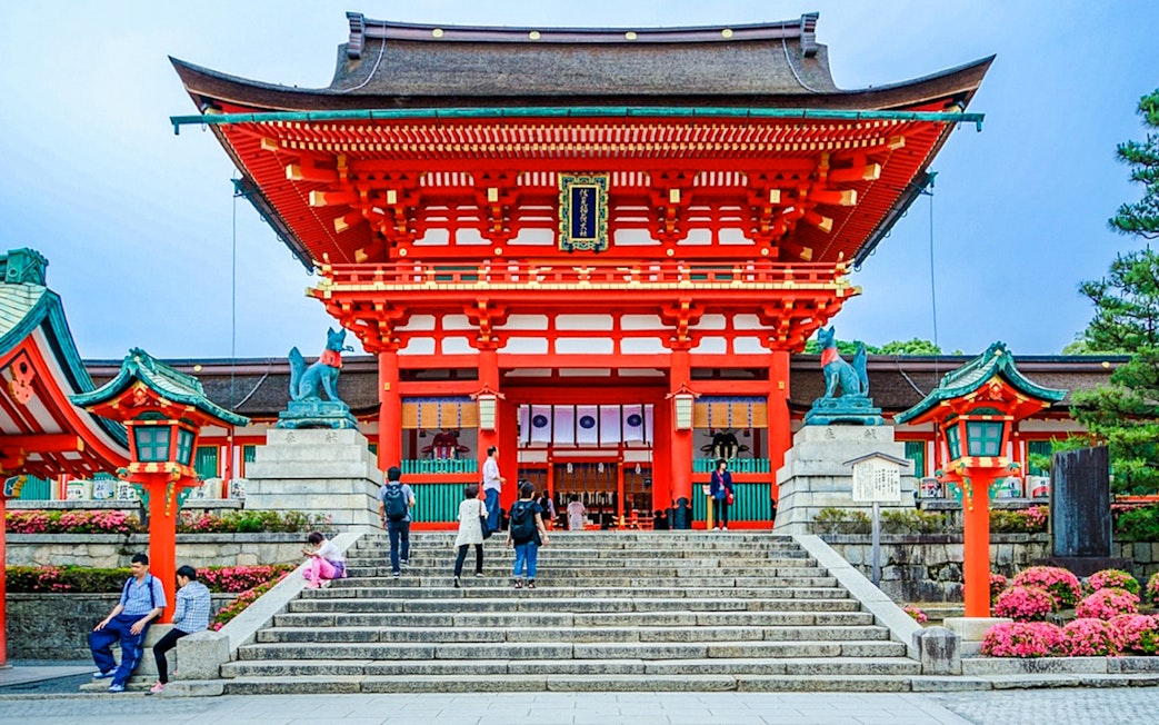 Fushimi Inari Taisha entrance with visitors on steps, Kyoto, Japan.