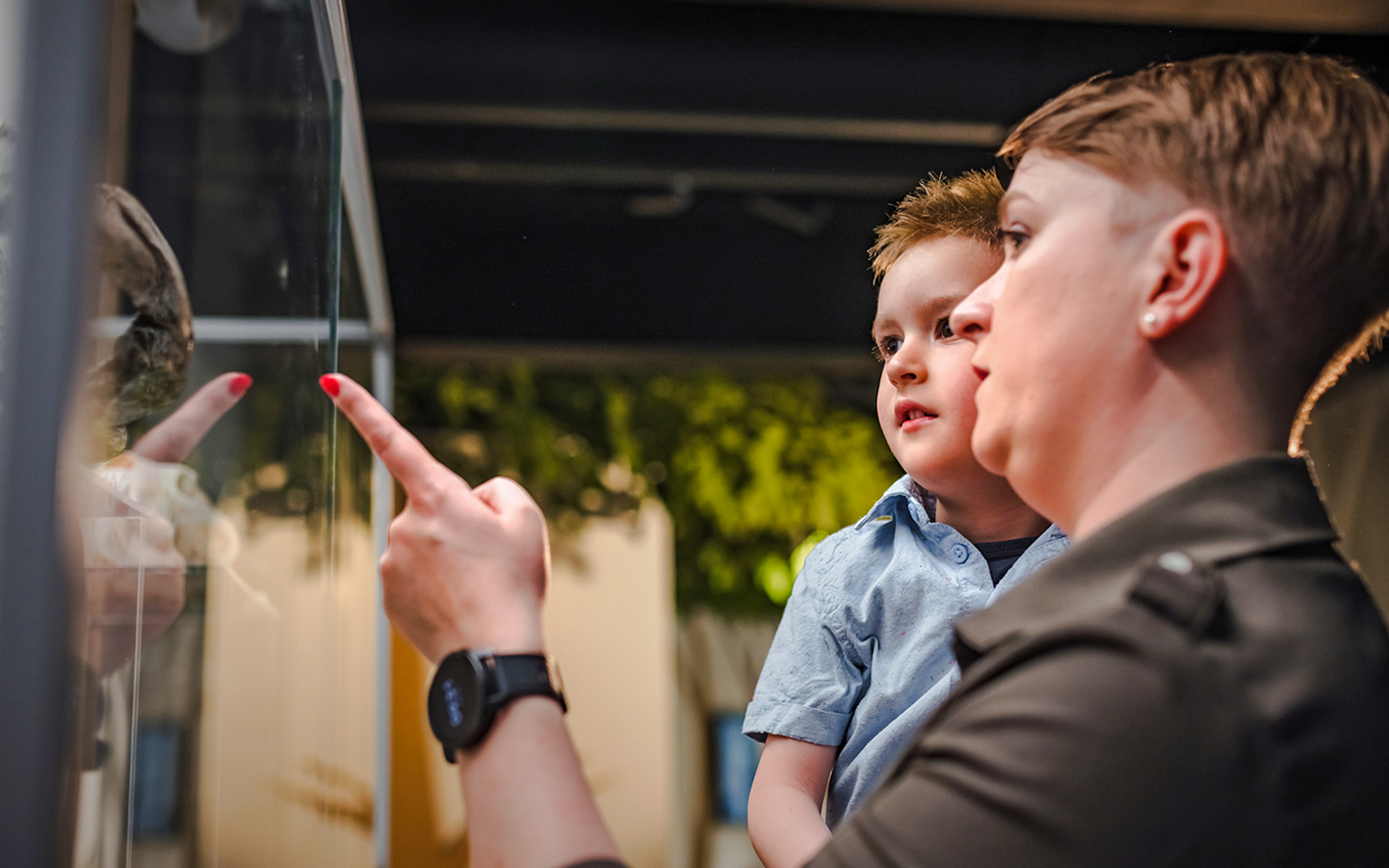 Mother and son observing exhibit inside museum.