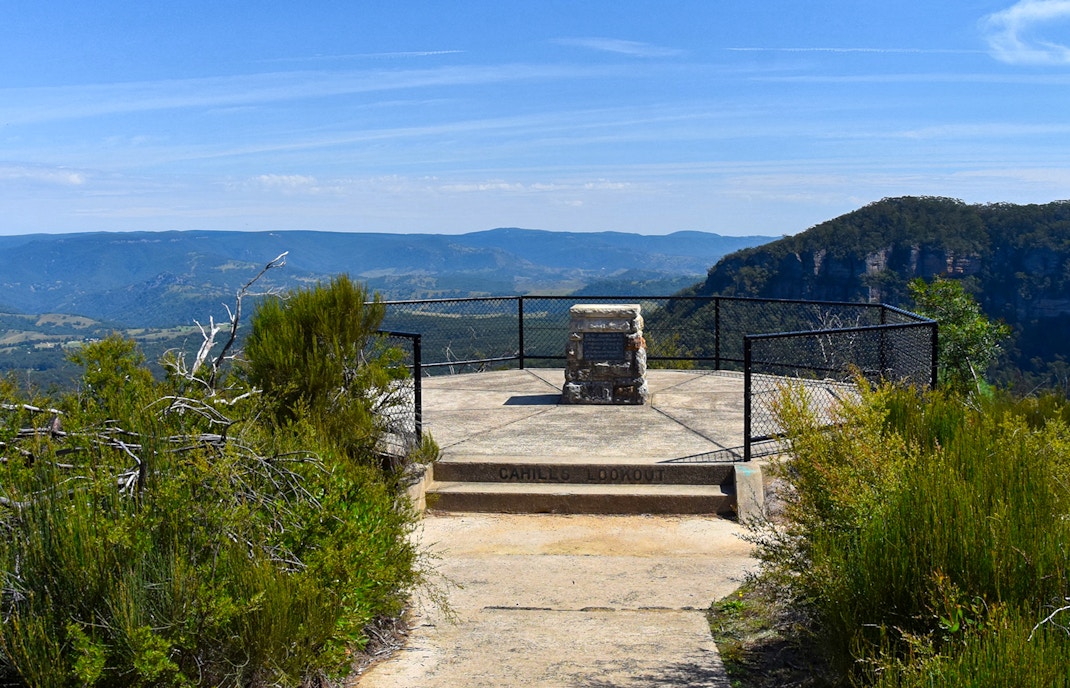 Cahill’s Lookout view of Blue Mountains with lush greenery and distant peaks.