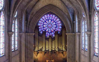 Stained glass rose window and organ inside Notre Dame Cathedral, Paris.
