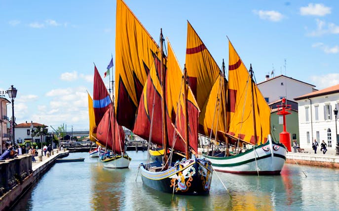 Colorful sailboats at Cesenatico Maritime Museum canal, Italy.