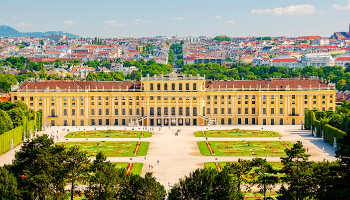 Schönbrunn Palace in Vienna with gardens and cityscape in the background.