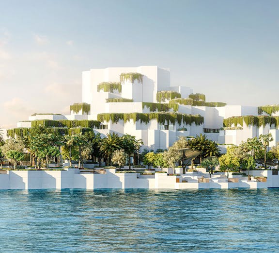 Aerial view of National History Museum Abu Dhabi with tiered white structures and greenery by the water.