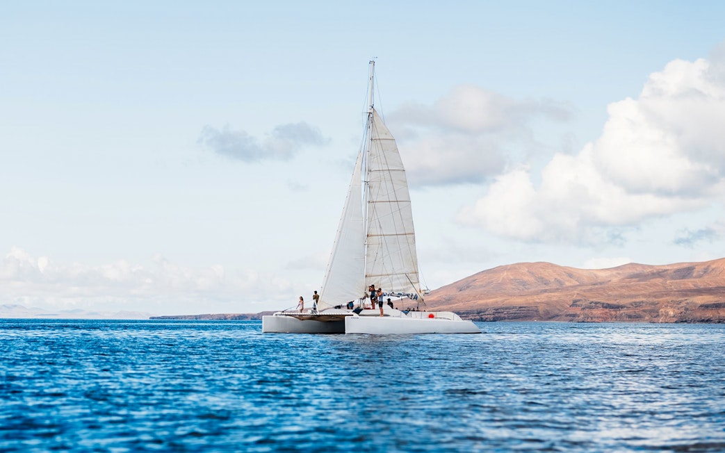Tourists on a catamaran in Lanzarote waters, heading to watch whales and dolphins.
