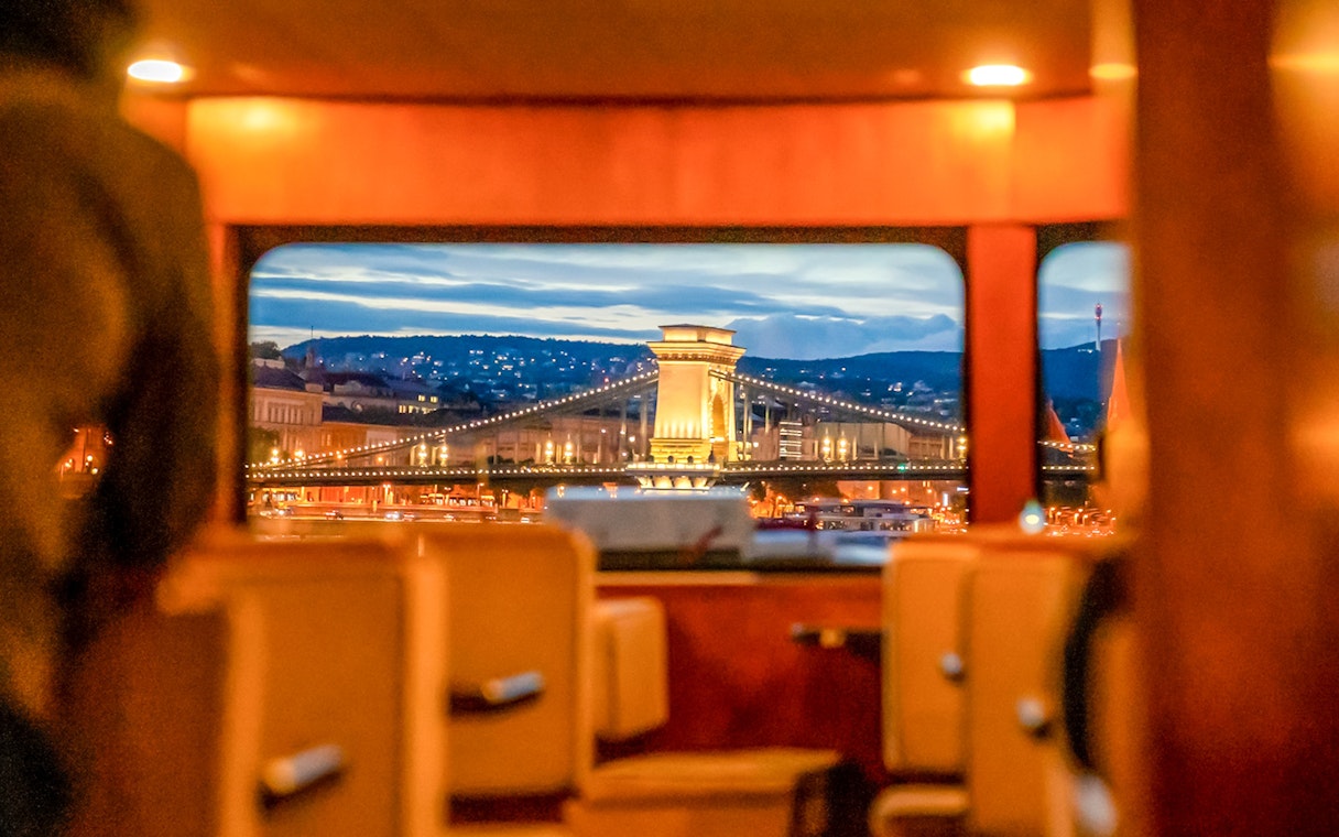 View of Budapest Chain Bridge from inside a cruise boat during sightseeing tour.