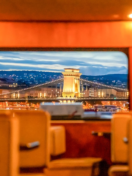 View of Budapest Chain Bridge from inside a cruise boat during sightseeing tour.
