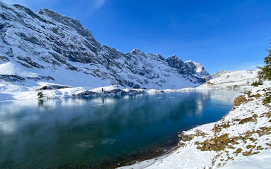 Snow-covered mountains and frozen lake at Trübsee during winter, view from Lucerne tour.