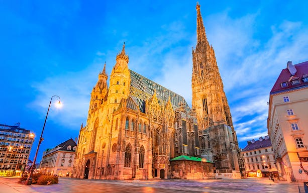 St. Stephen's Cathedral in Vienna at dusk with illuminated facade.
