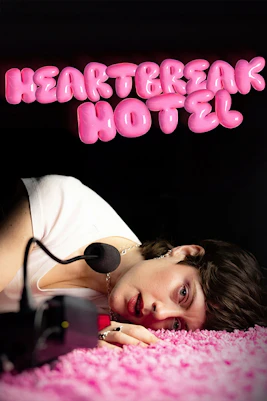 Person lying on pink carpet with microphone, "Heartbreak Hotel" text above.