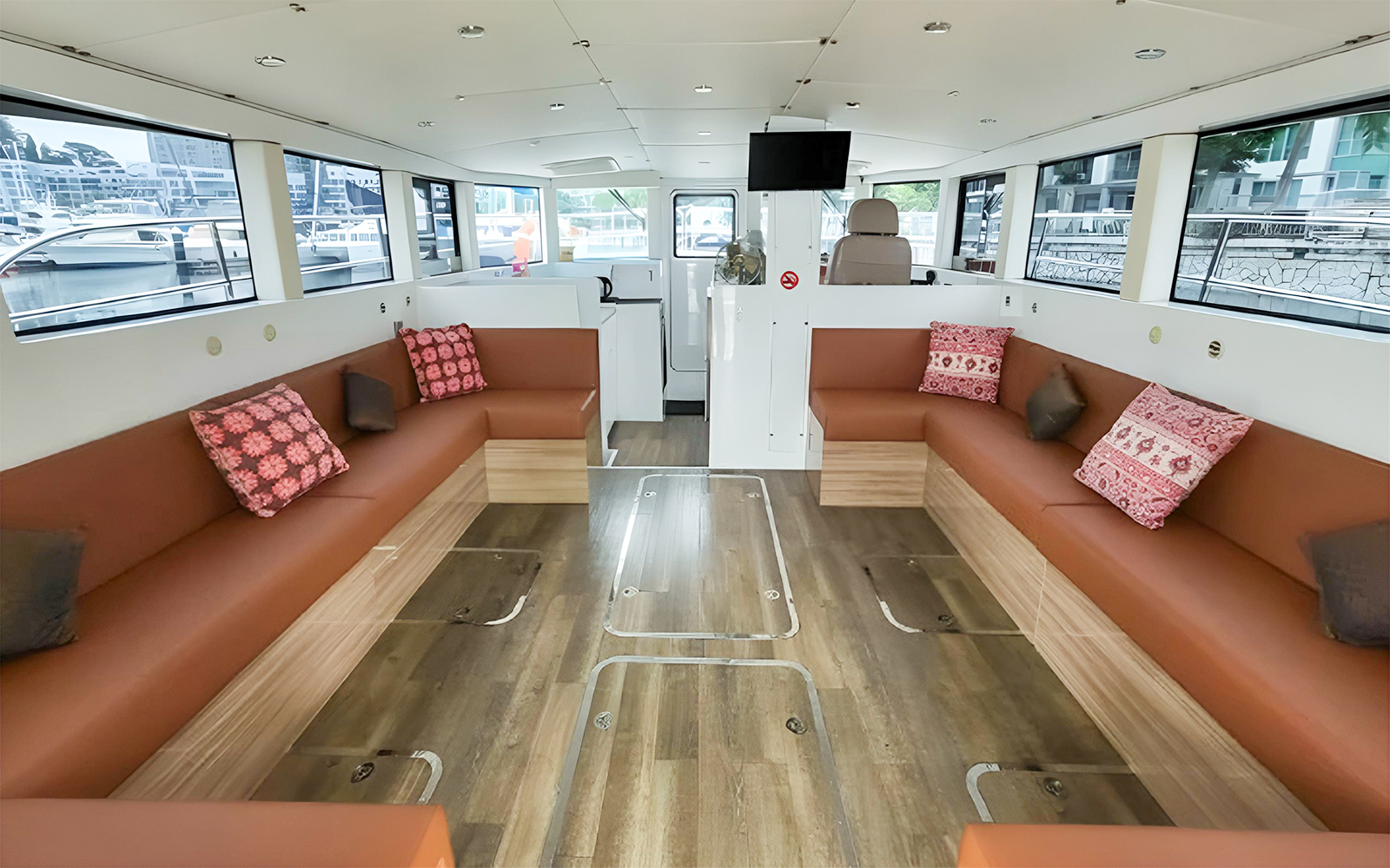 Interior of SunRise yacht with seating area and large windows at the marina.