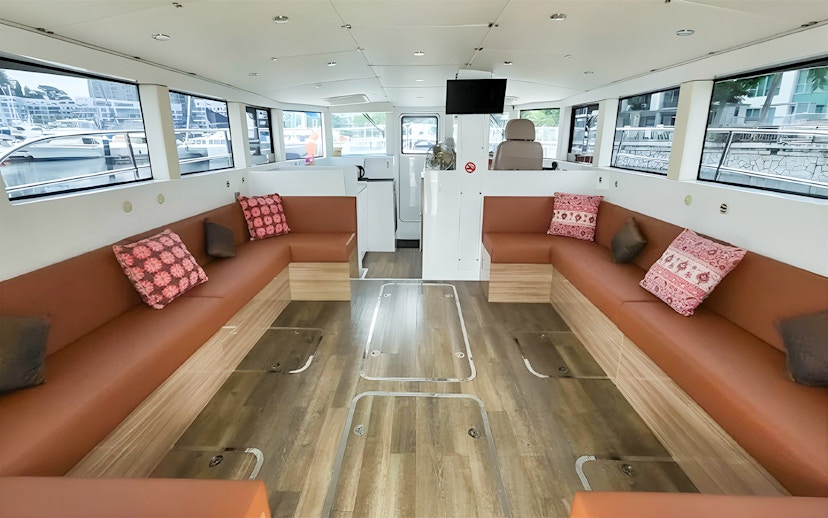 Interior of SunRise yacht with seating area and large windows at the marina.