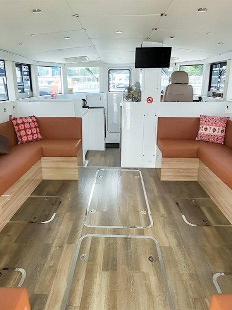 Interior of SunRise yacht with seating area and large windows at the marina.