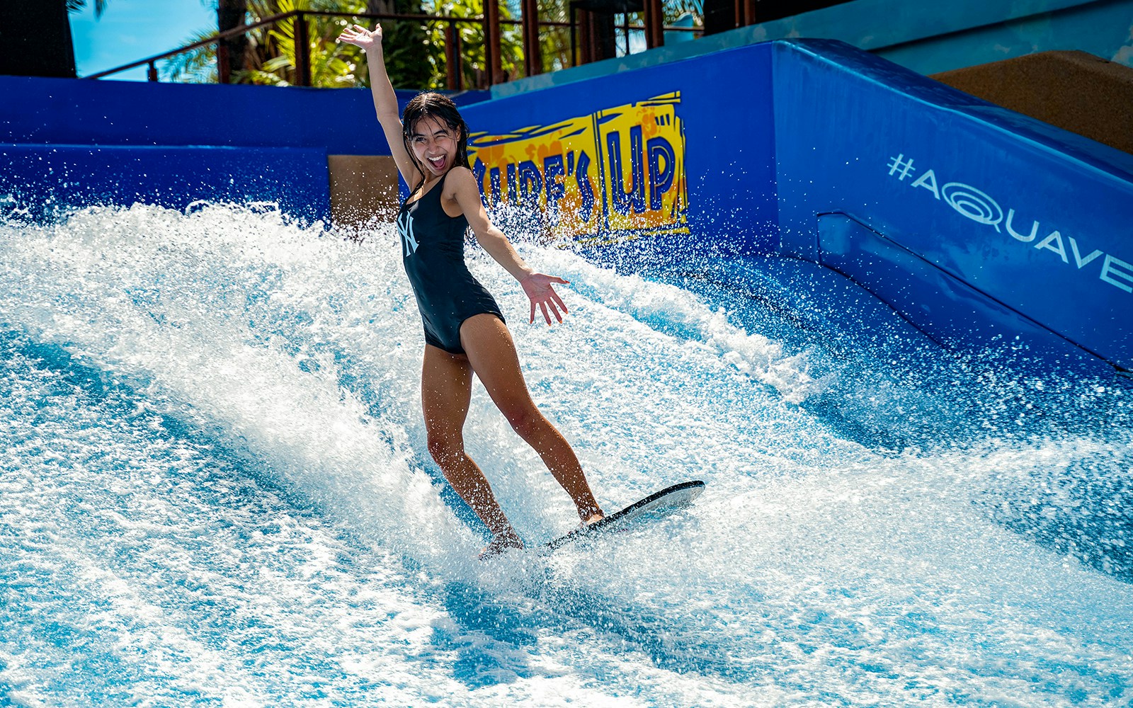 Person surfing on artificial wave at Columbia Pictures Aquaverse Pattaya.