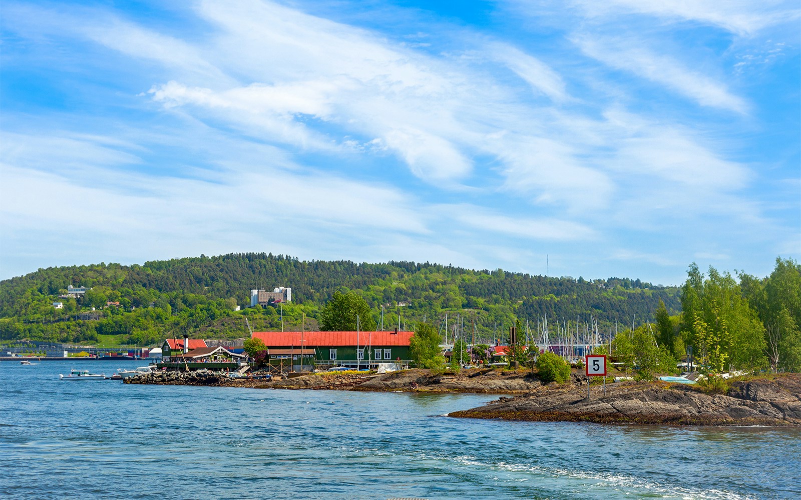 Hovedøya Island waterfront with red-roofed buildings and boats near Oslo.