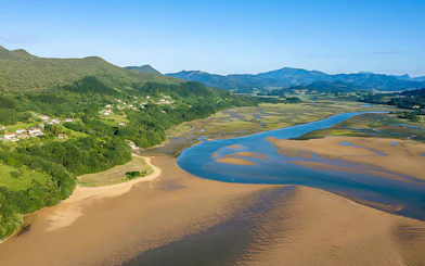 Urdaibai estuary landscape with winding river and lush green hills in Spain.
