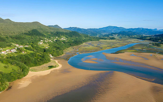 Urdaibai estuary landscape with winding river and lush green hills in Spain.