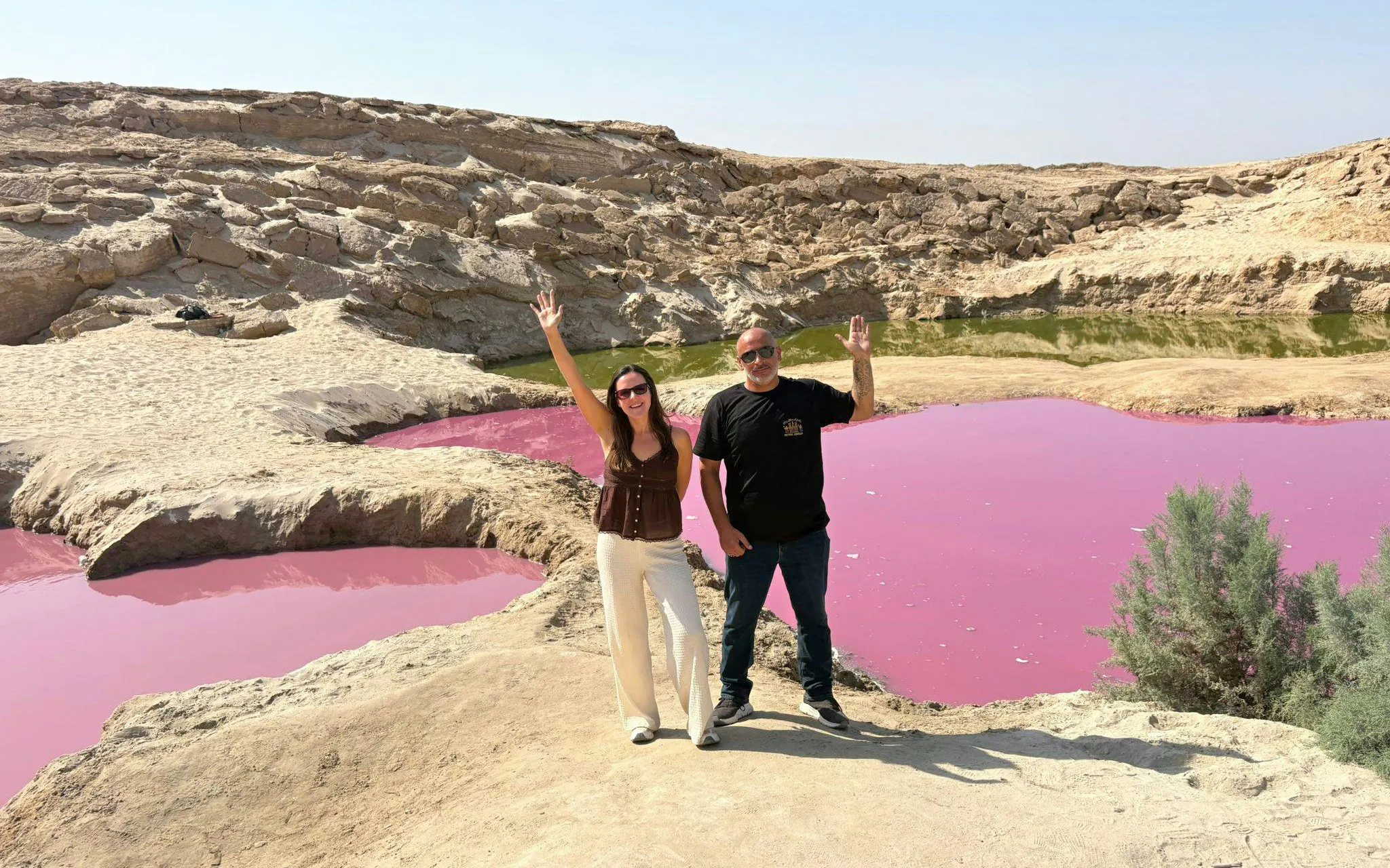 Tourists at pink water pools in Wadi Rum desert, part of a 2-day tour from Amman to Petra and Dead Sea.