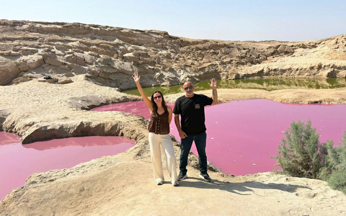 Tourists at pink water pools in Wadi Rum desert, part of a 2-day tour from Amman to Petra and Dead Sea.