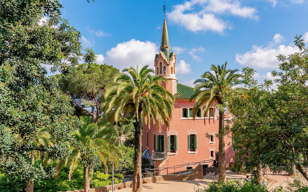 Park Guell Gaudi House Museum surrounded by palm trees in Barcelona.