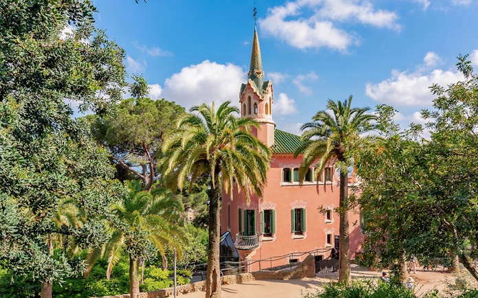 Park Guell Gaudi House Museum surrounded by palm trees in Barcelona.