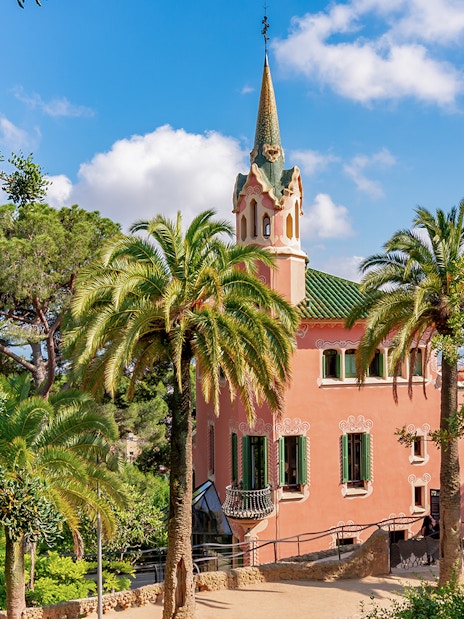 Park Guell Gaudi House Museum surrounded by palm trees in Barcelona.