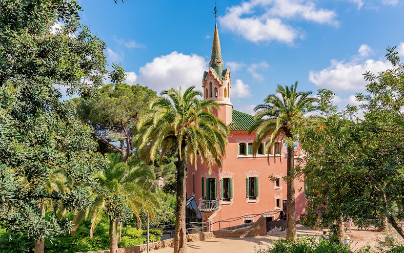 Park Guell Gaudi House Museum surrounded by palm trees in Barcelona.