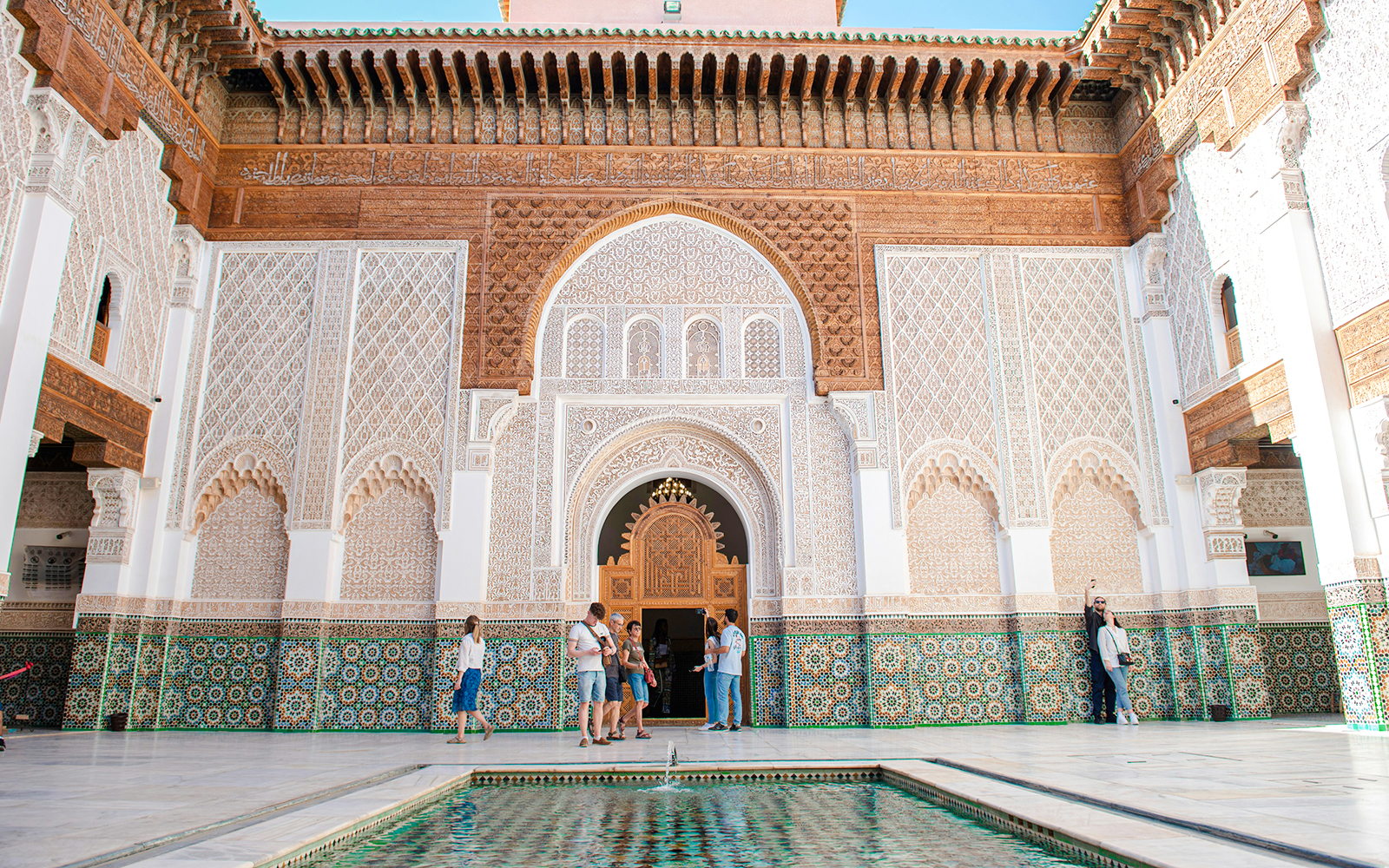 Ben Youssef Madrasa courtyard with intricate tilework in Marrakech, Morocco.