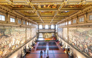 Palazzo Vecchio Hall of the Five Hundred with ornate ceiling and historic frescoes, Florence, Italy.