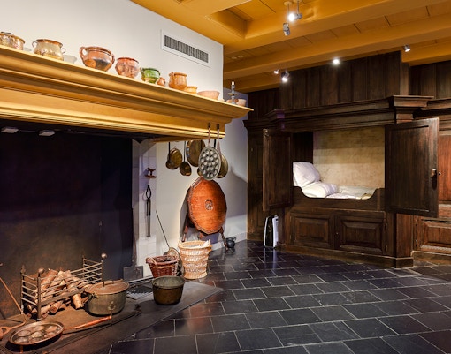Rembrandt House Museum interior with historic kitchen and wooden bed alcove.