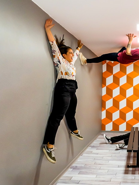 Visitors experiencing anti-gravity room at Museum of Illusions Seville.