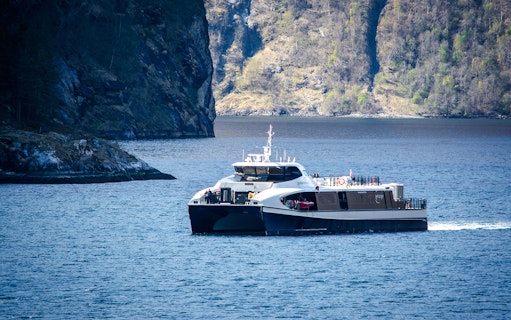 Ferry cruising through the Silent Fjord in Alesund, Norway.