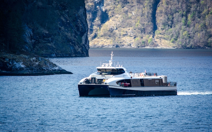 Ferry cruising through the Silent Fjord in Alesund, Norway.