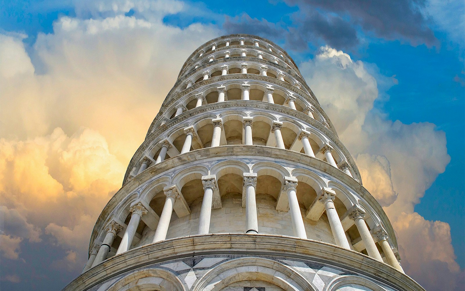 Leaning Tower of Pisa against a dramatic cloudy sky.