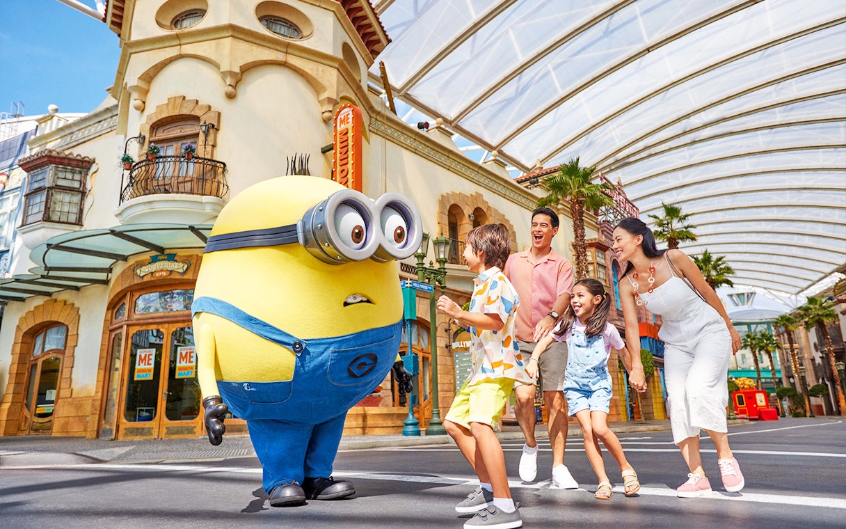 Family interacting with a Minion character at Universal Studios Singapore.