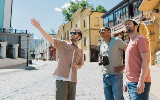 Tourists exploring a historic street with a guide pointing out landmarks.