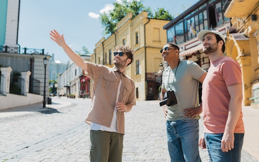 Tourists exploring a historic street with a guide pointing out landmarks.
